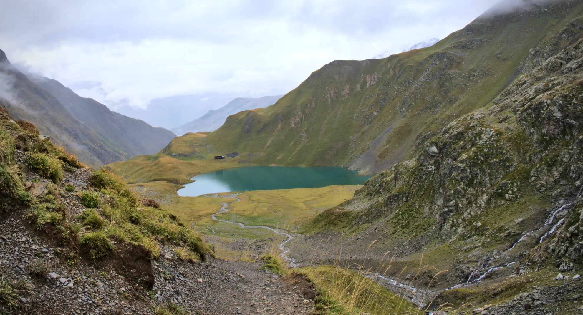 Lac de la Muzelle sett fra nedstien, med hytta ved vannkanten