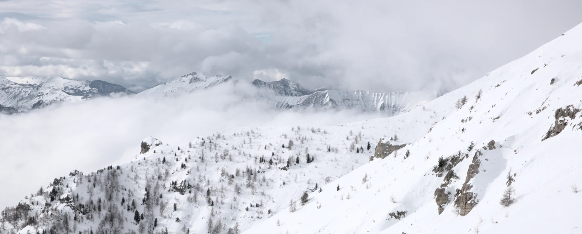 Snødekt side av Vieux Chaillol over et skyhav